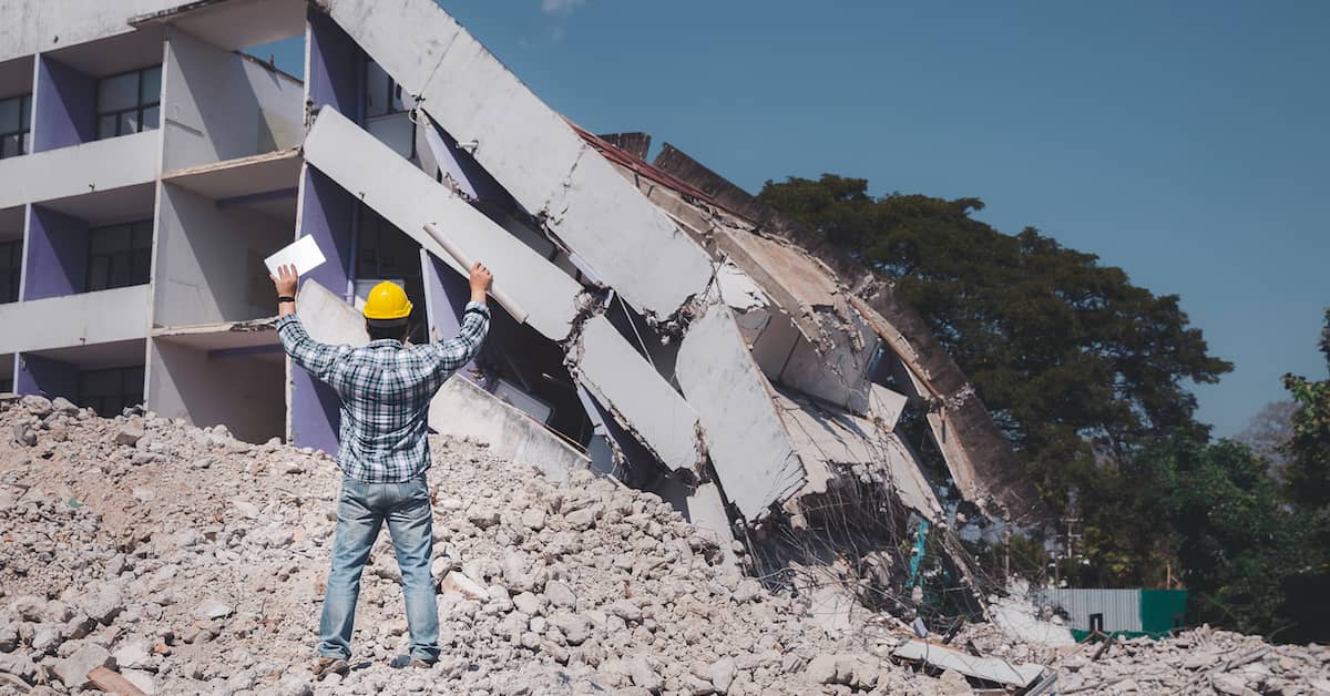 construction worker surveying structural collapse of a building