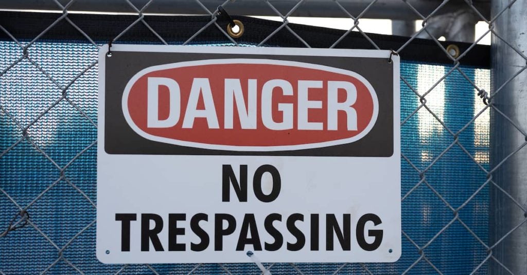 Danger: No Trespassing sign on fence at construction site