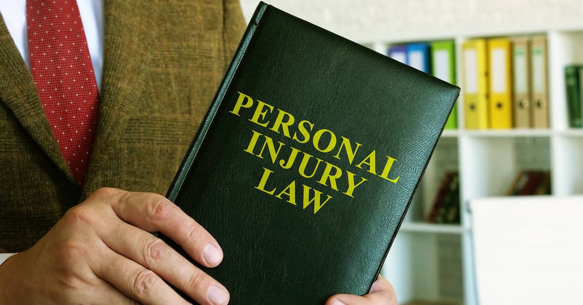 attorney holding a book titled Personal Injury Law
