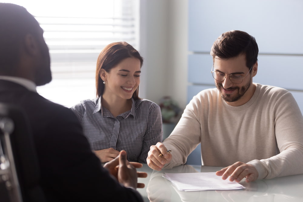 couple reviewing and signing documents during a meeting with a lawyer
